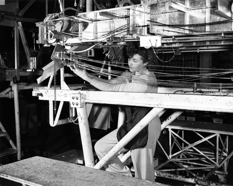A woman engineer connects flight deck control wires